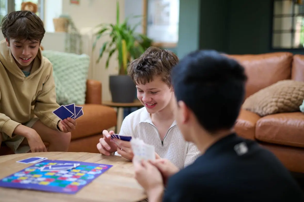 Three students playing boardgame