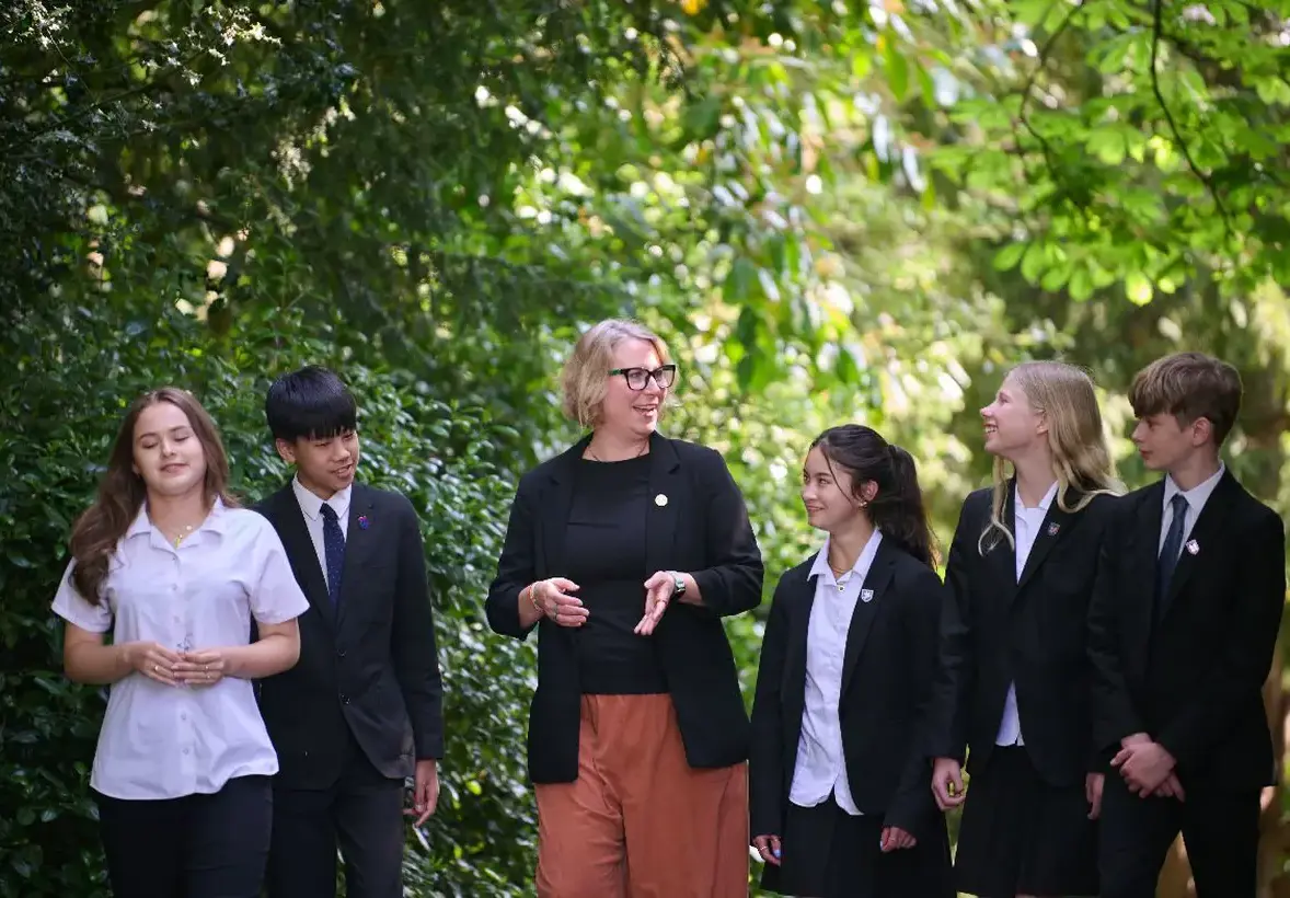 Teacher outside talking with group of students