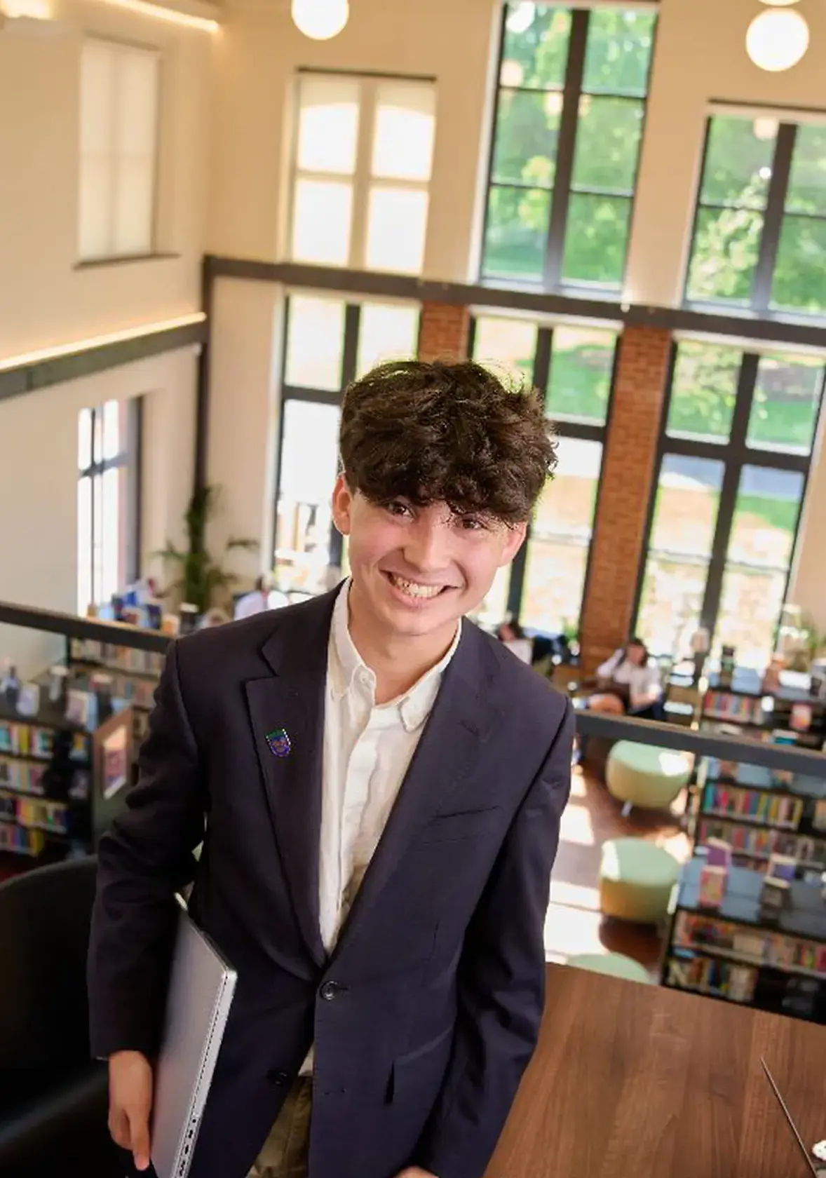 Happy young male student in library