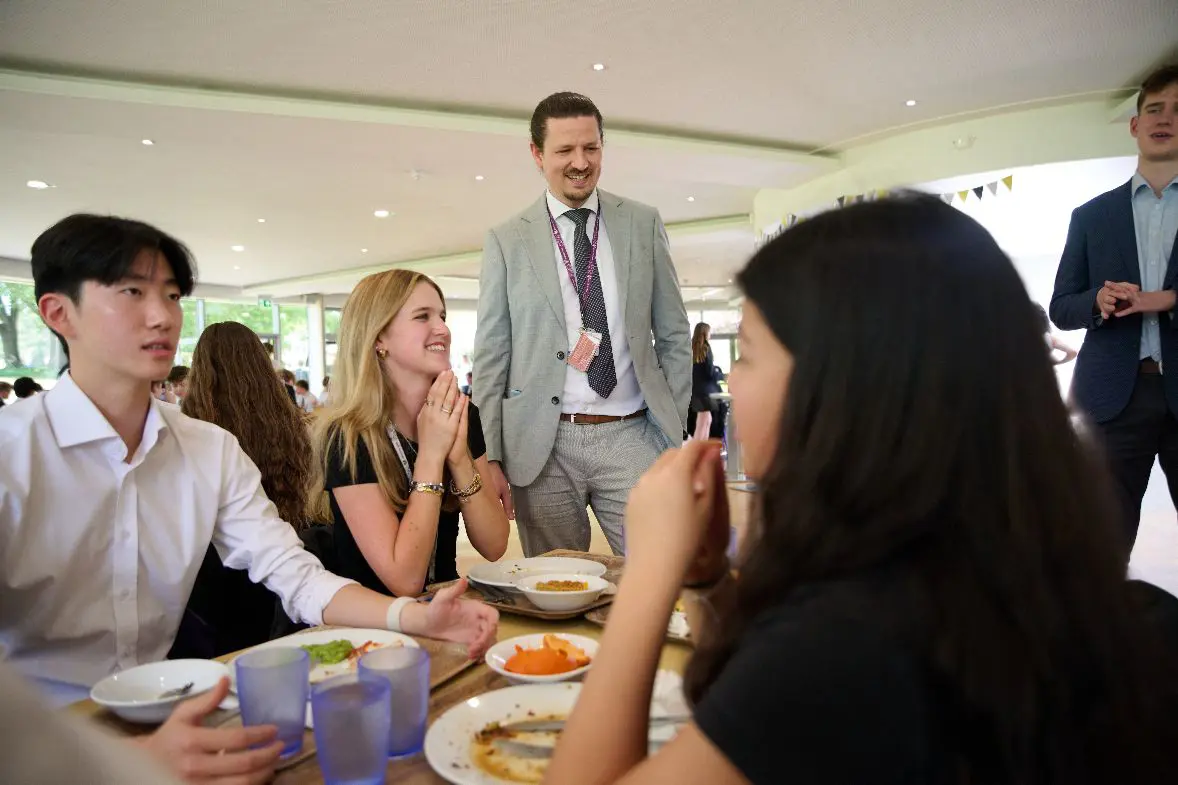 Teacher talking with students at lunch