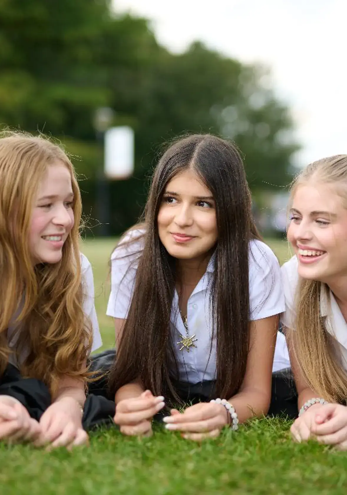 Three girls lying on grass