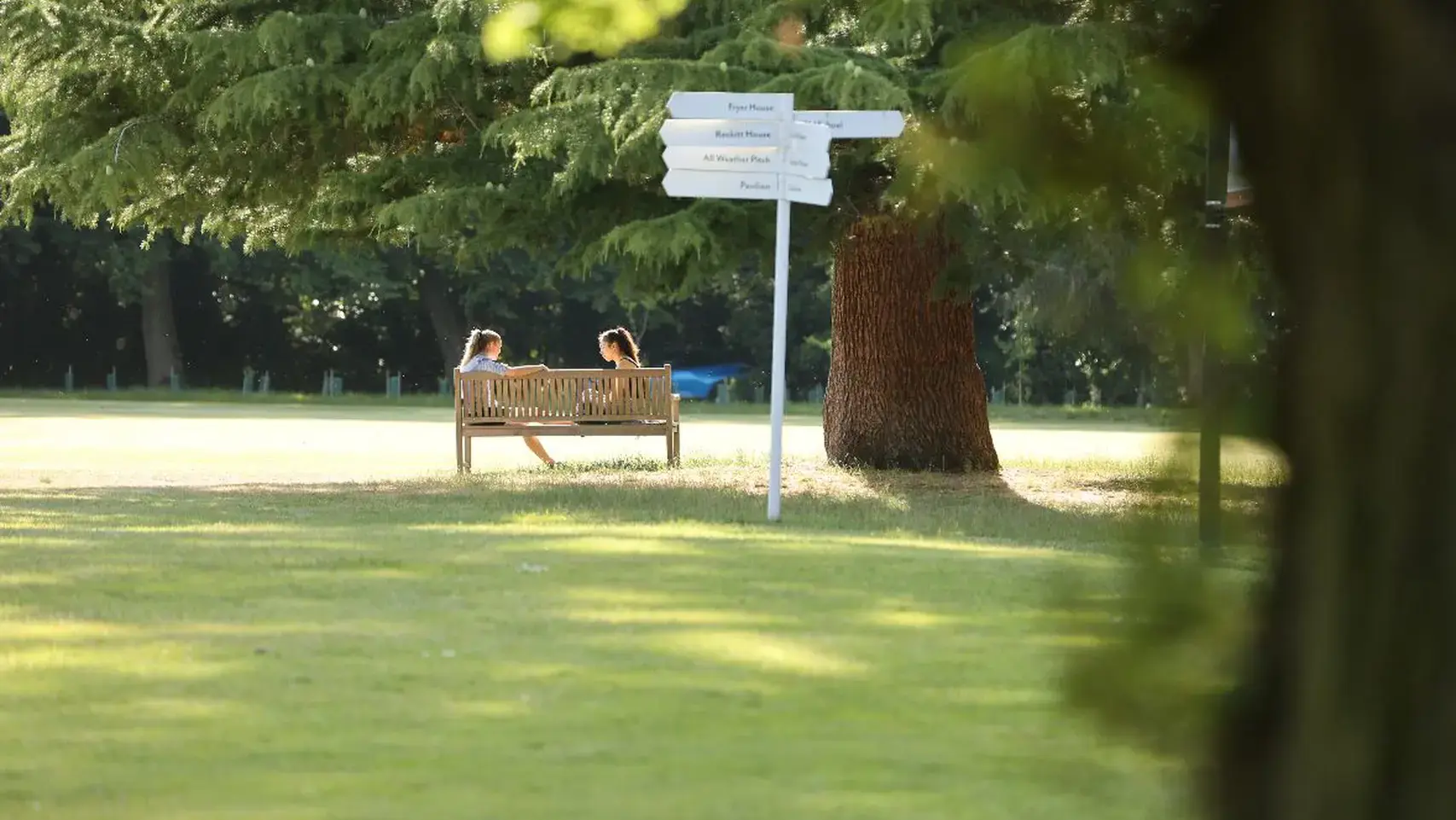Students on bench by location signpost