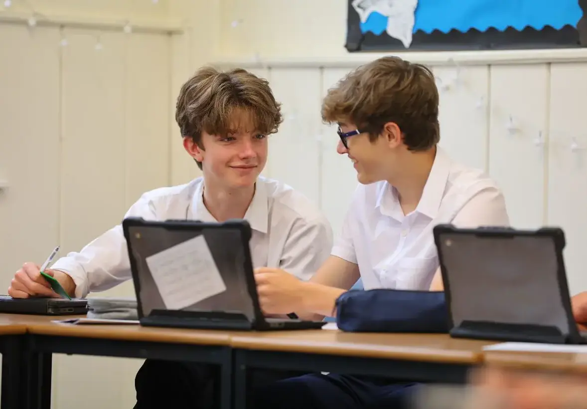 Male students in classroom with laptops